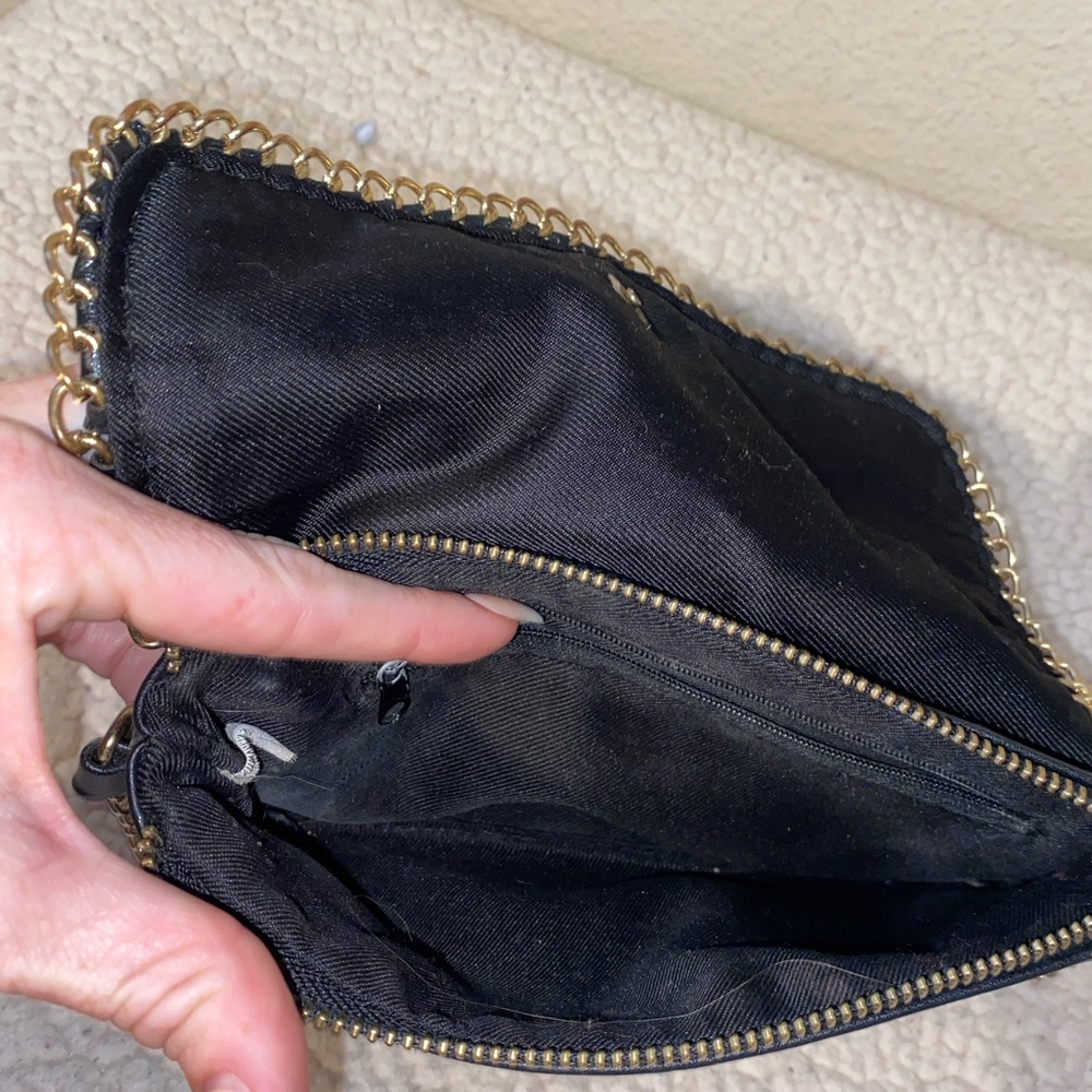 Black cross body purse with gold chain.